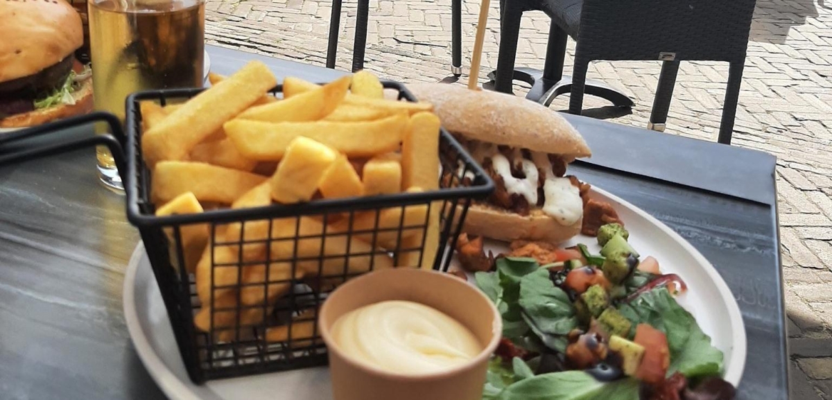 Bild eines Tellers mit Pommes Frites und Shawarma-Sandwich auf der Terrasse